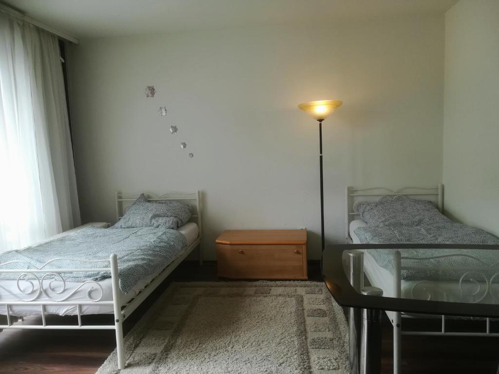 汉诺威Hannover Messe Wohnung 2的一间卧室设有两张床、一盏灯和一扇窗户。