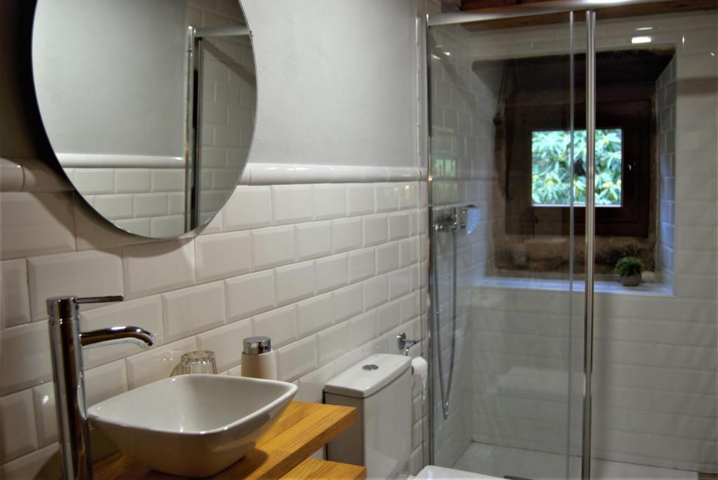 NavedoApartamentos El Abertal的浴室配有盥洗盆和带镜子的淋浴