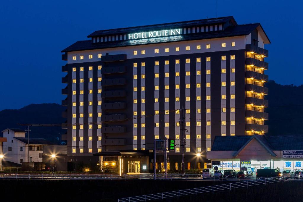 津山市Hotel Route-Inn Tsuyama Ekimae的一间酒店房间,晚上有照明建筑