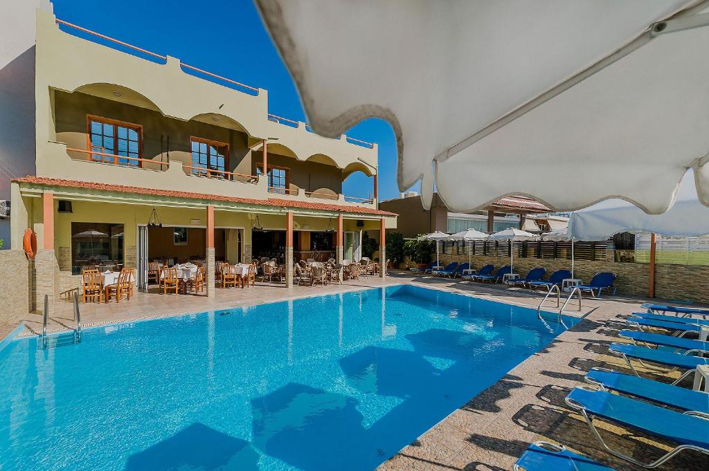 克雷马斯蒂埃斯梅拉达酒店的一座带蓝色椅子的建筑前的游泳池