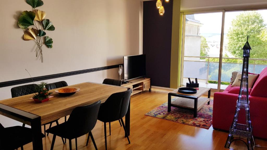 埃佩尔奈L'épopée de l'Avenue - Parking - Avenue de Champagne - Epernay的客厅配有木桌和红色沙发