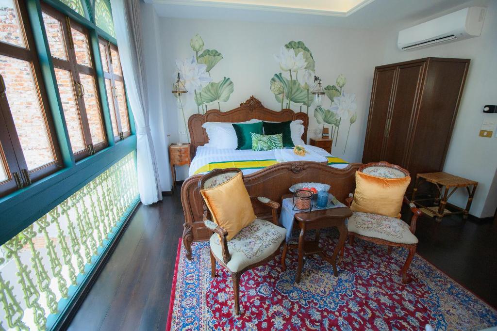曼谷The Knight House Bangkok的一间卧室配有一张床、两把椅子和一张桌子