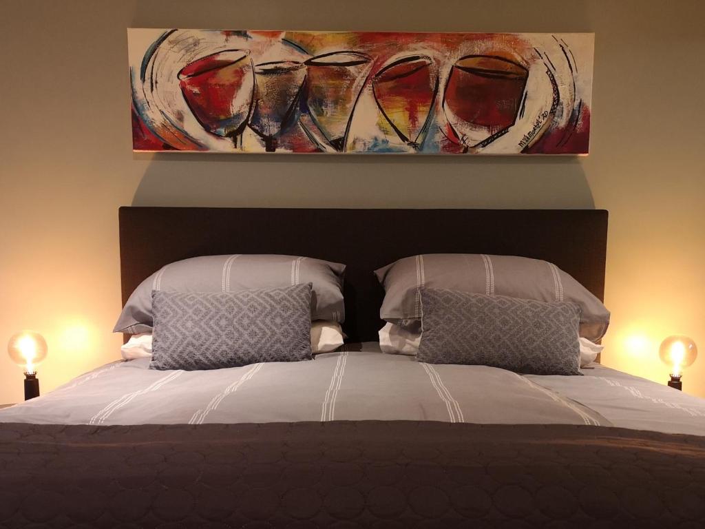 SwalmenDe Eppenbeek的一张带两个枕头的床和墙上的绘画