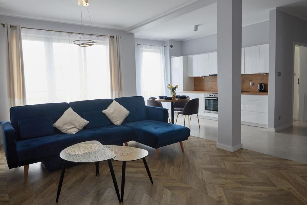 大波兰地区奥斯特鲁夫Luksusowy Apartament的客厅配有蓝色的沙发和桌子