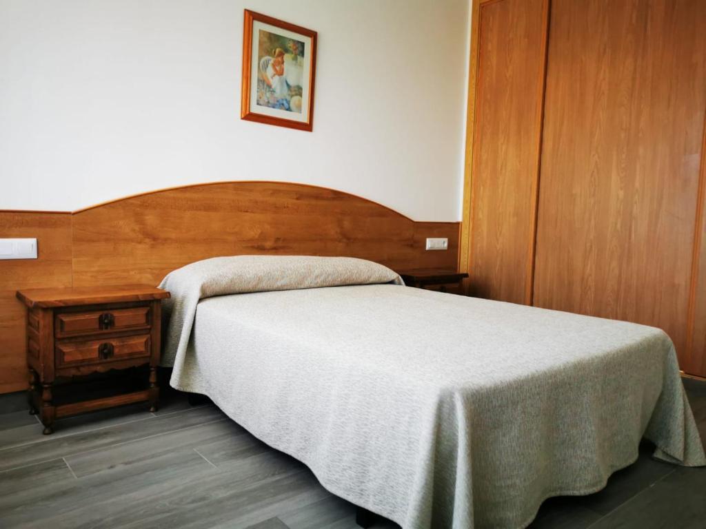 圣维森德马尔Loft Pedras Negras的一间卧室配有一张床和一个木制床头板