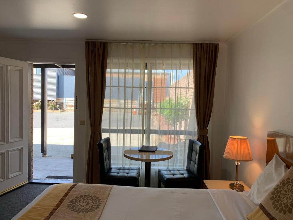 亚斯昂首阔步汽车旅馆的酒店客房带一张床、一张桌子和椅子