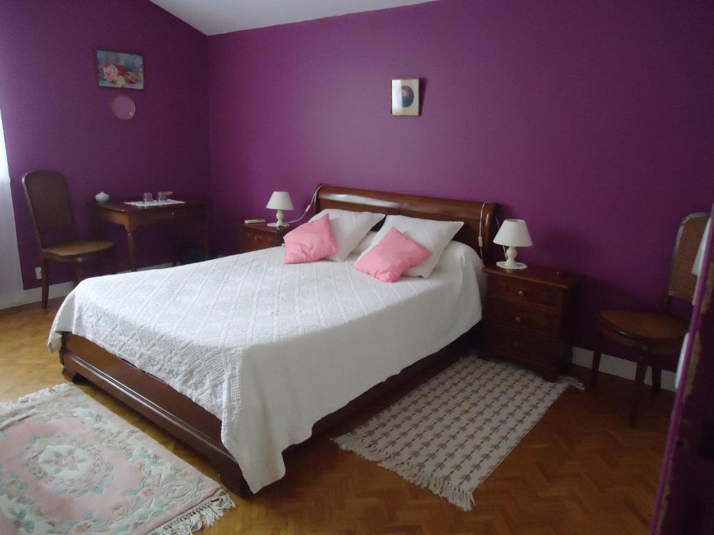 CarignanA la Cerisaie的一间卧室设有紫色的墙壁和一张带粉红色枕头的床