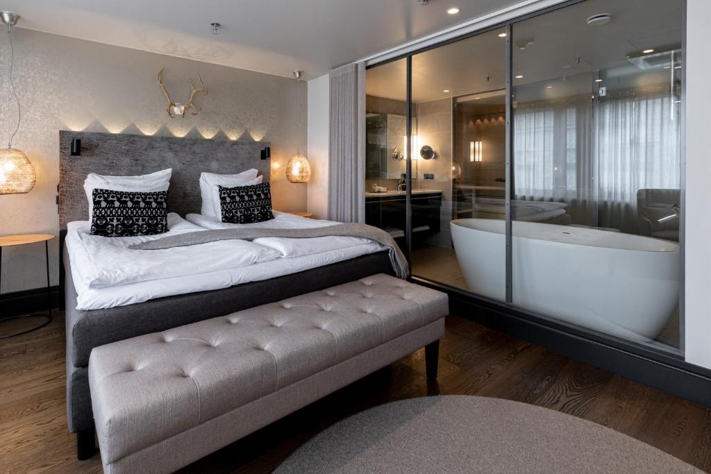 赫尔辛基Lapland Hotels Bulevardi的一间卧室设有一张大床和一个浴缸