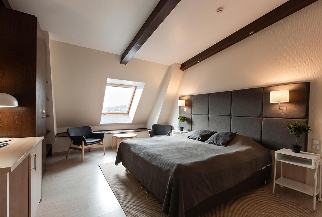 摩尔曼斯克格拉鲁斯酒店的一间卧室配有一张床、一张书桌和一个窗户。