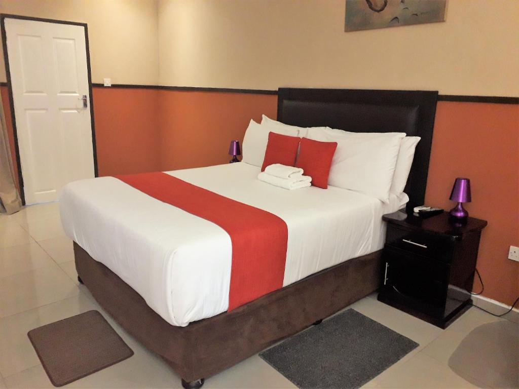 弗朗西斯敦River View Villa Self Catering的一间卧室配有一张带红色和白色枕头的大床