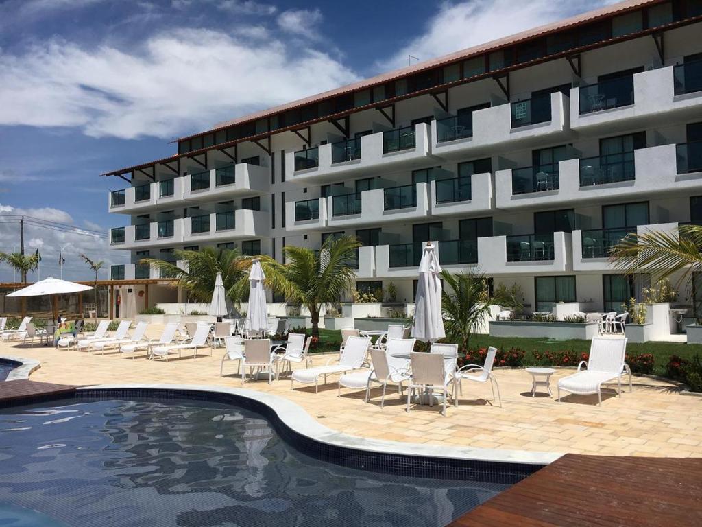 嘎林海斯港LAGUNA BEACH FLAT EM PORTO的一座带游泳池和椅子的酒店和一座建筑