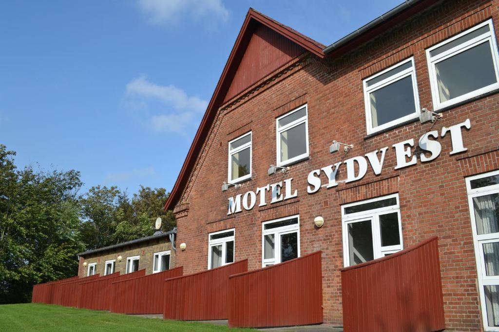斯凯拜克Motel Sydvest的一座红砖建筑,用世界风格的西语写字