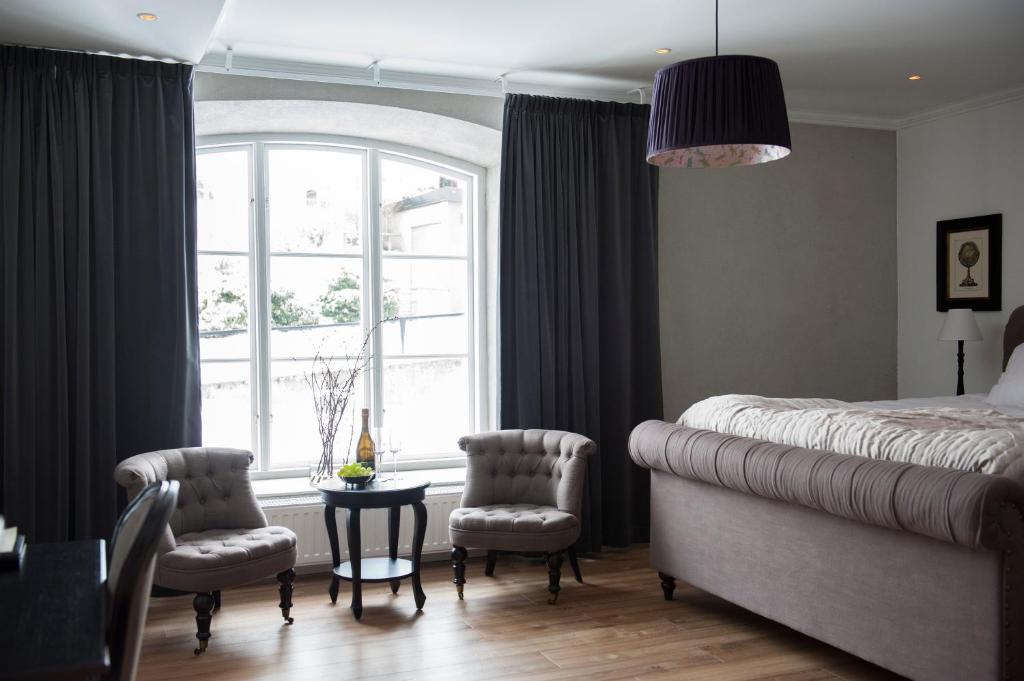 维斯比斯洛兹贝肯酒店的一间卧室配有一张床、两把椅子和一个窗户
