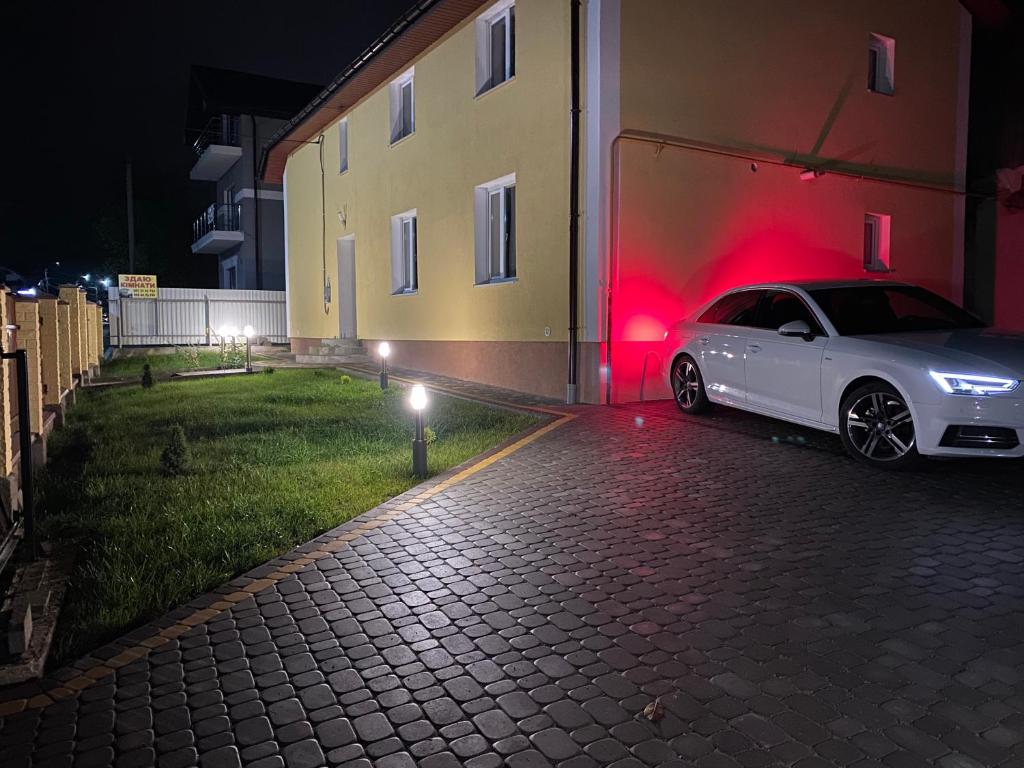 斯基希德尼萨Villa Vella的夜间停在大楼旁边的白色汽车