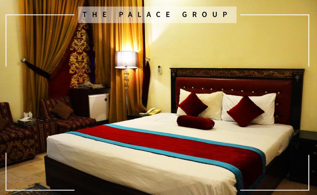 拉合尔Rose Palace Hotel, Liberty的酒店客房配有一张带红色枕头的大床