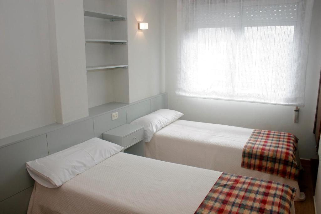 美洲海滩Apartamentos Angelito的小房间设有两张床和窗户