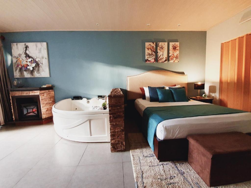 福尔图纳Yellow Tree Suites的卧室配有床和浴缸,毗邻一个sidx sidx sidx床