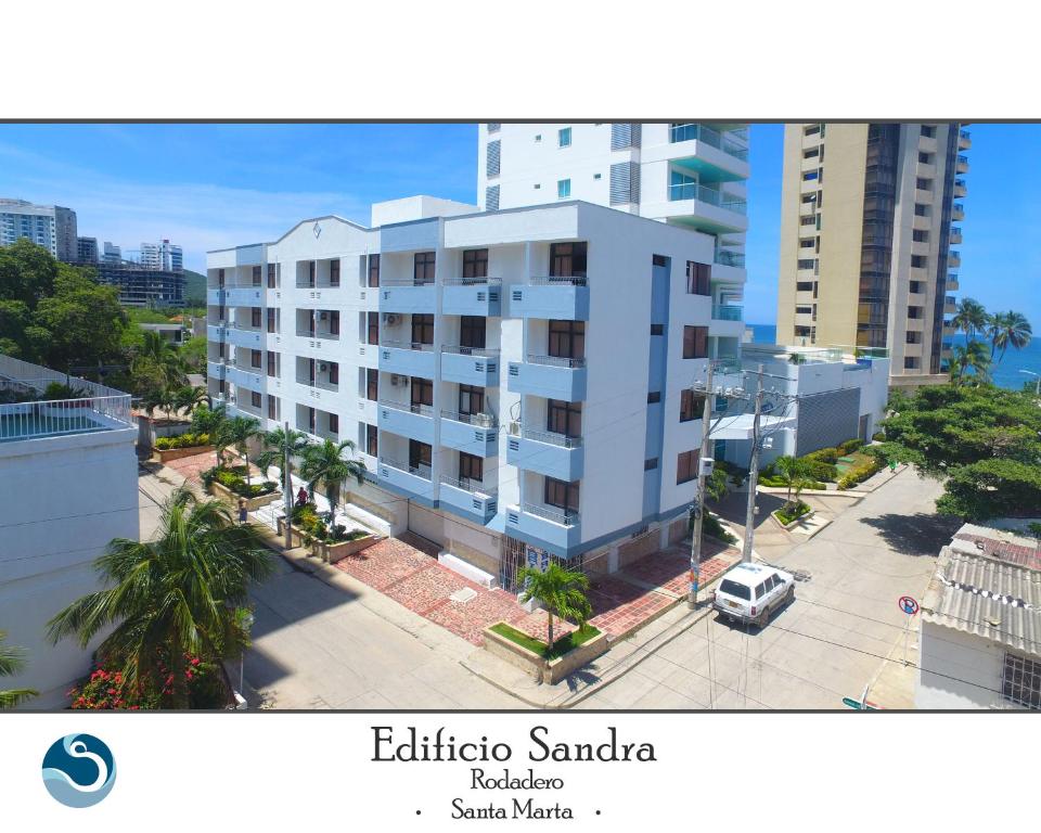 圣玛尔塔Edificio Sandra的前面有一辆汽车停放的白色建筑