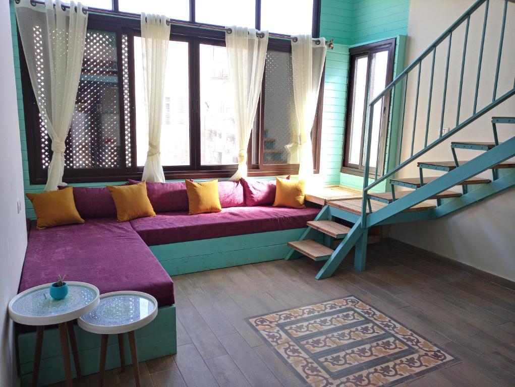 纳布卢斯Turquoise的一间带紫色沙发和楼梯的客厅