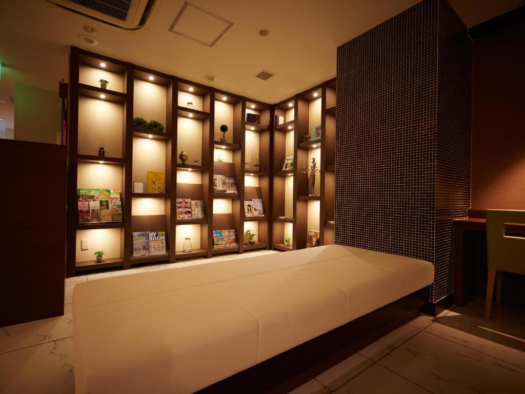 水户Super Hotel Mito的一间墙上挂着灯的床铺