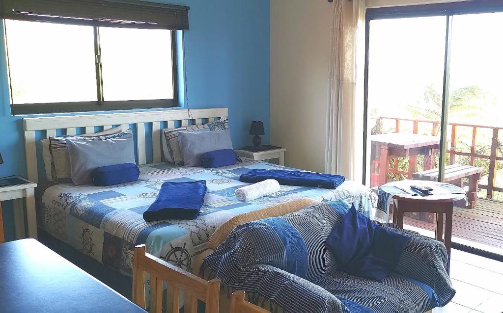 东伦敦霍伊莱克旅馆的一间卧室配有一张带蓝色床单的床和一把椅子