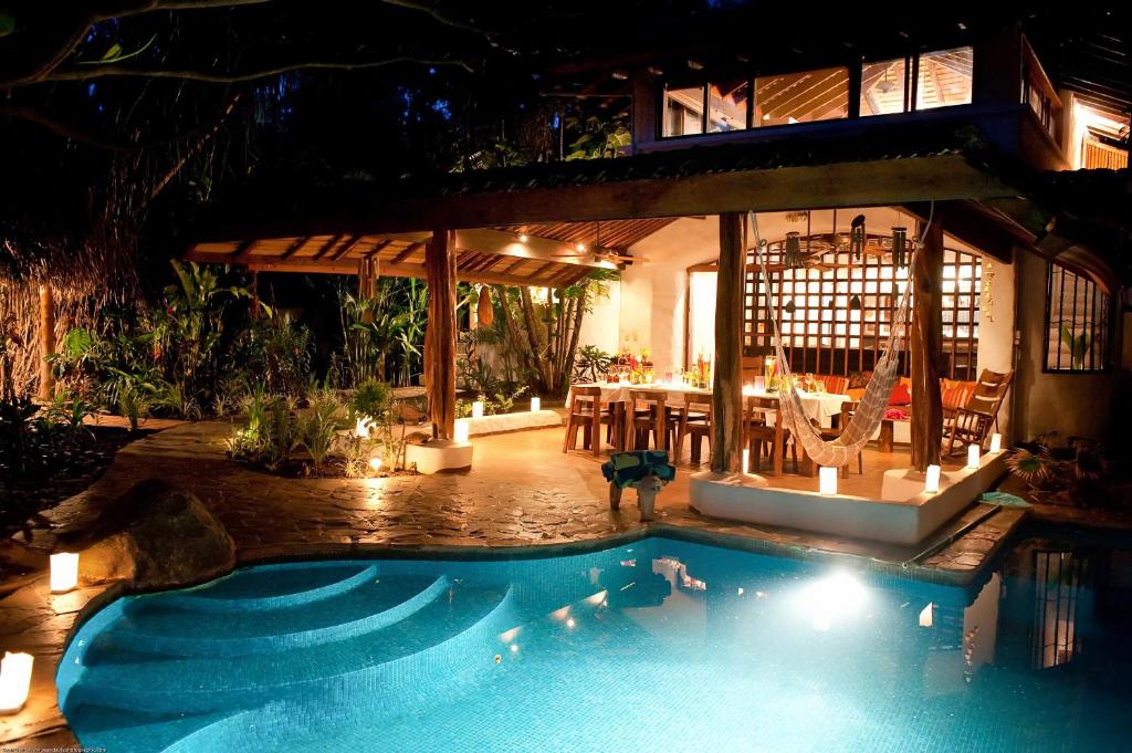 塔马林多Sueño del Mar Beachfront Hotel的夜间别墅前的游泳池