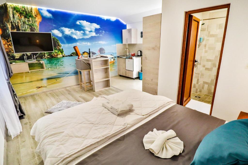 波德戈里察Simo apartments airport Podgorica的卧室配有一张大床,墙上挂有绘画作品