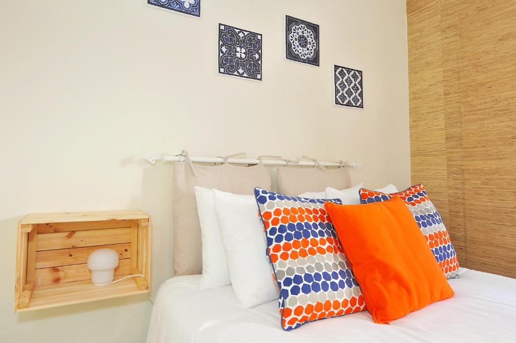 里斯本Cosy Bedrooms Guest House的一张白色的床,上面有色彩缤纷的枕头