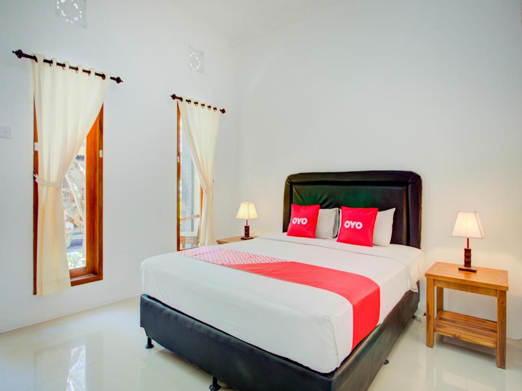 金巴兰Vivaldi Jimbaran的一间卧室配有一张带红色枕头的床和一扇窗户