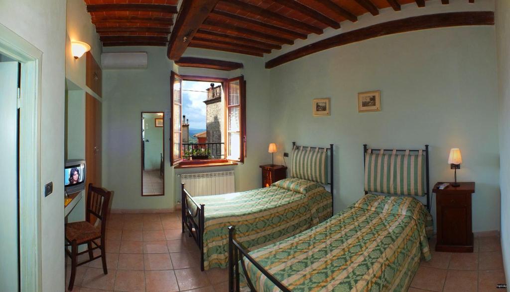 Civitella Marittima甲板住宿加早餐旅馆的酒店客房设有两张床和窗户。