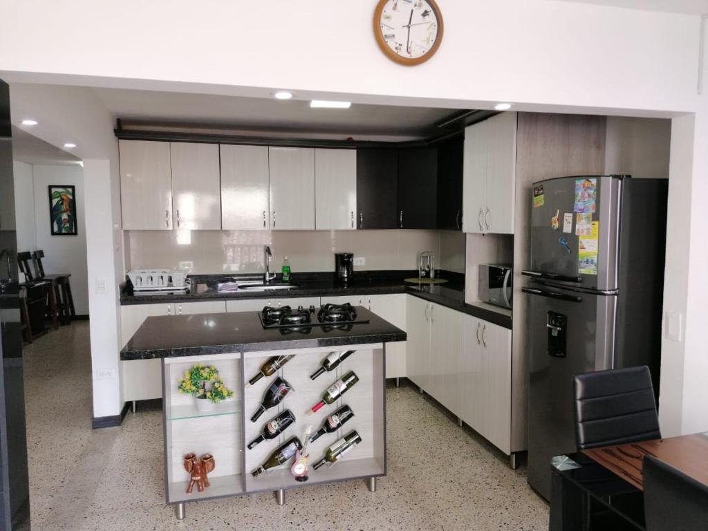 瓜塔佩Casa Melodía Guatapé - Excelente Ubicación - Calle del Comercio的厨房配有白色橱柜和黑色冰箱。