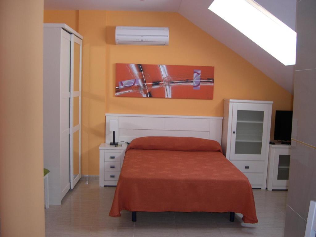 托梅略索牵牛花住宿旅游公寓的一间卧室配有一张橙色墙壁的床