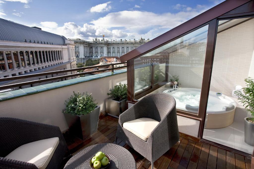 马德里歌剧院酒店的大楼内的阳台配有浴缸和椅子