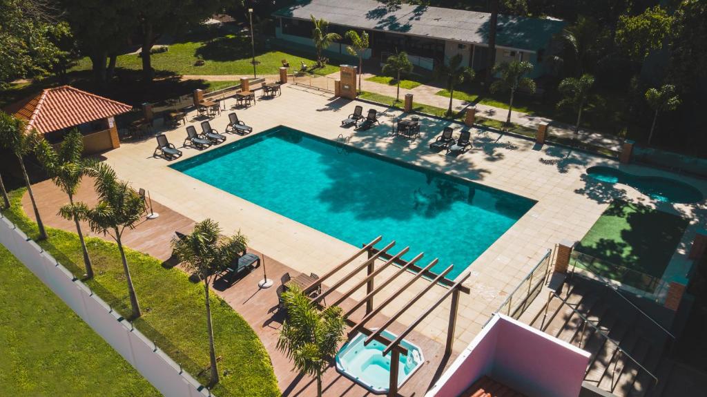 伊瓜苏Cataratas Park Hotel e Eventos的游泳池的顶部景色,周围的人坐在游泳池周围