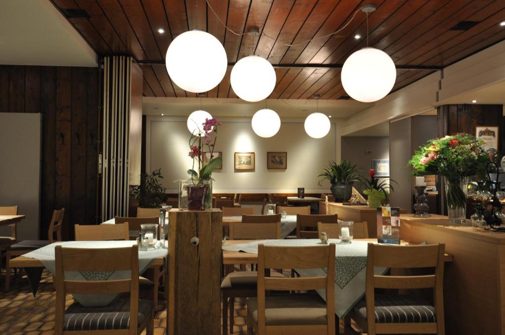 特里芬Gasthaus Sonne GbR的一间带桌椅和灯光的餐厅