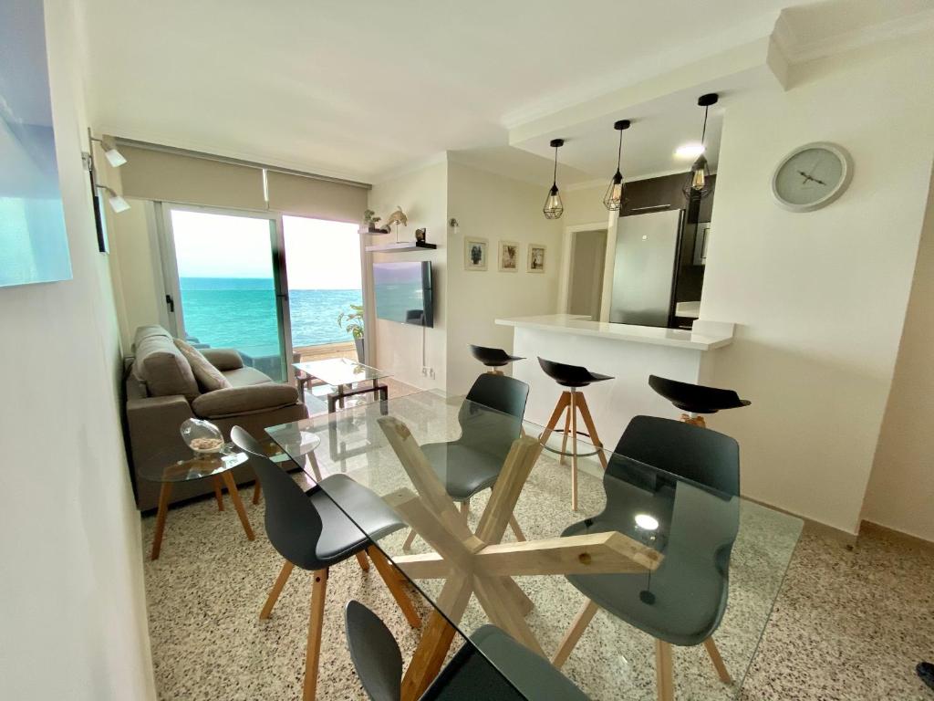 大加那利岛拉斯帕尔马斯Hermoso edificio Frente al mar con gran terraza y hermosas vistas的客厅配有玻璃桌和椅子