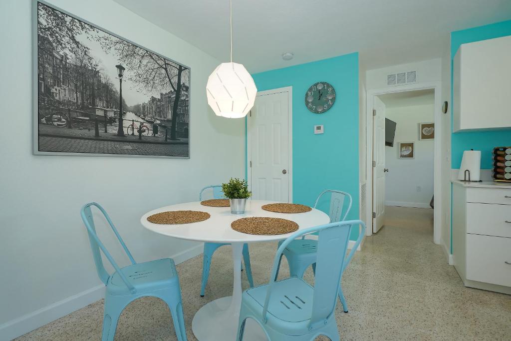 萨拉索塔Modern & Fresh - Less than 3 miles to the Beach!的一间配备有白色桌子和蓝色椅子的用餐室