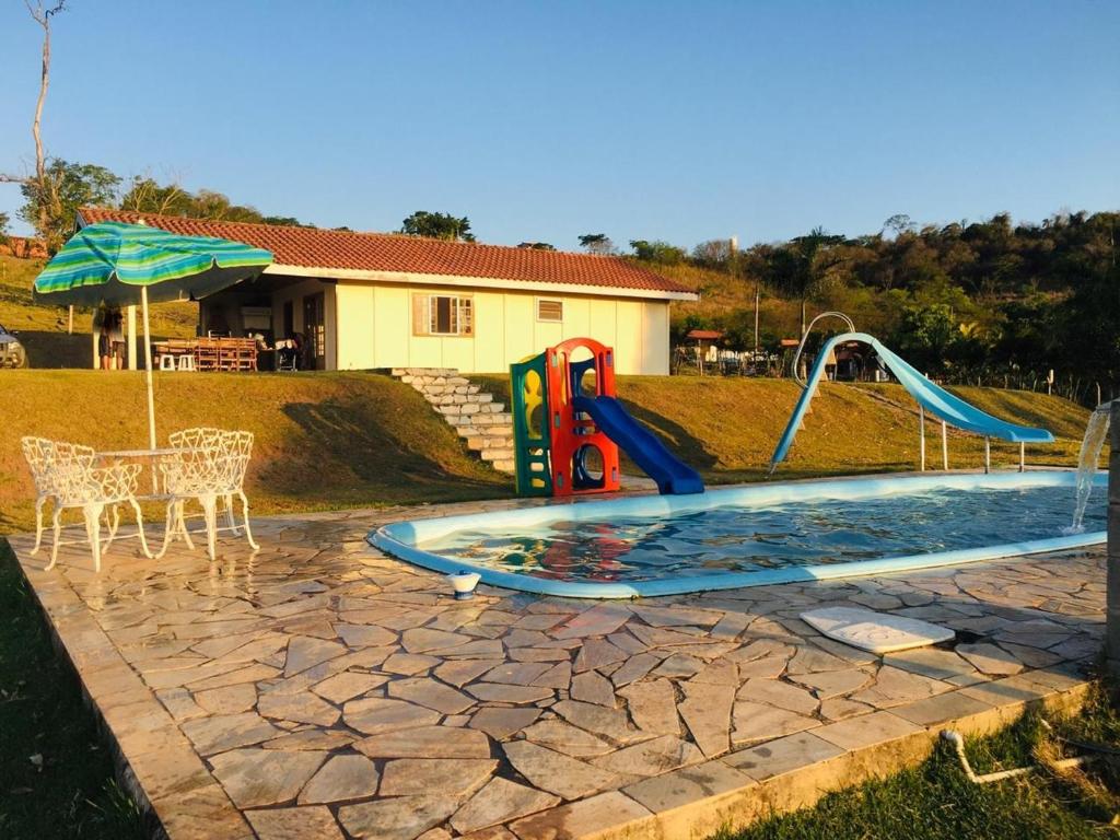 PorangabaSítio Santo Agostinho的一个带滑梯和游乐场的小游泳池