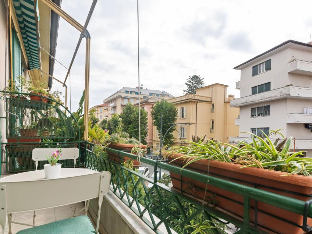 拉瓦尼亚Belvilla by OYO Casa Rosa的阳台配有白色桌子、椅子和植物