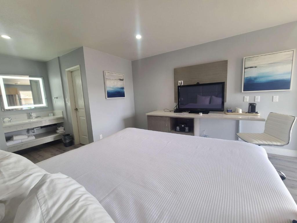 奥兰治贝斯特韦斯特奥兰治广场酒店的卧室配有白色的床和电视。