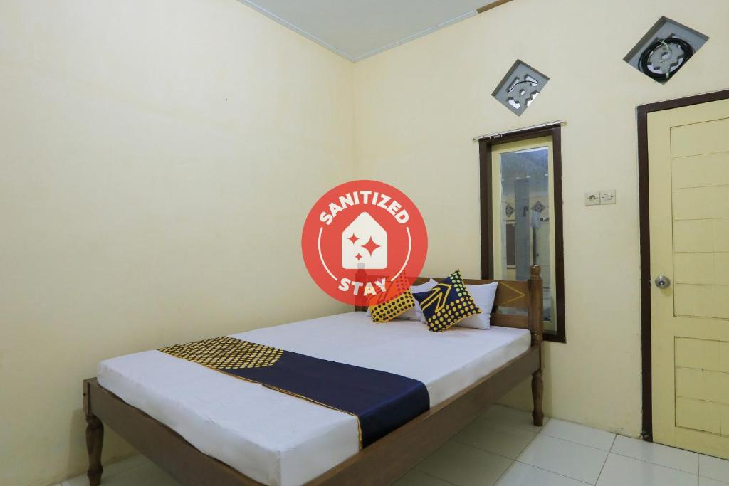 BlimbingsariOYO 2371 Islami Family Residence的一间卧室,床上有红色标志