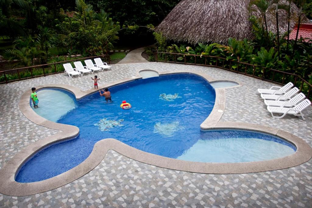 托尔图格罗Turtle Beach Lodge的一个小型游泳池,其中有两人