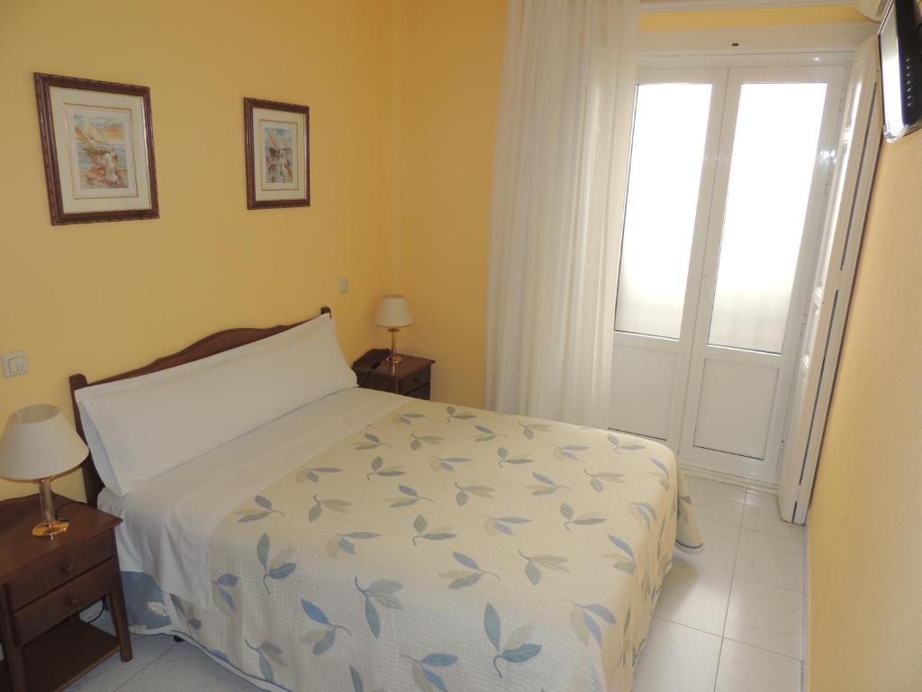 马德里冈萨洛旅馆的一间卧室设有一张床和一个窗口