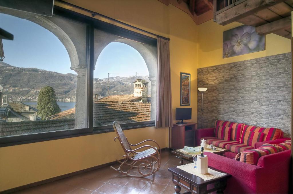 奥尔塔圣朱利奥Appartamenti Orta的客厅设有2张红色的沙发和大窗户