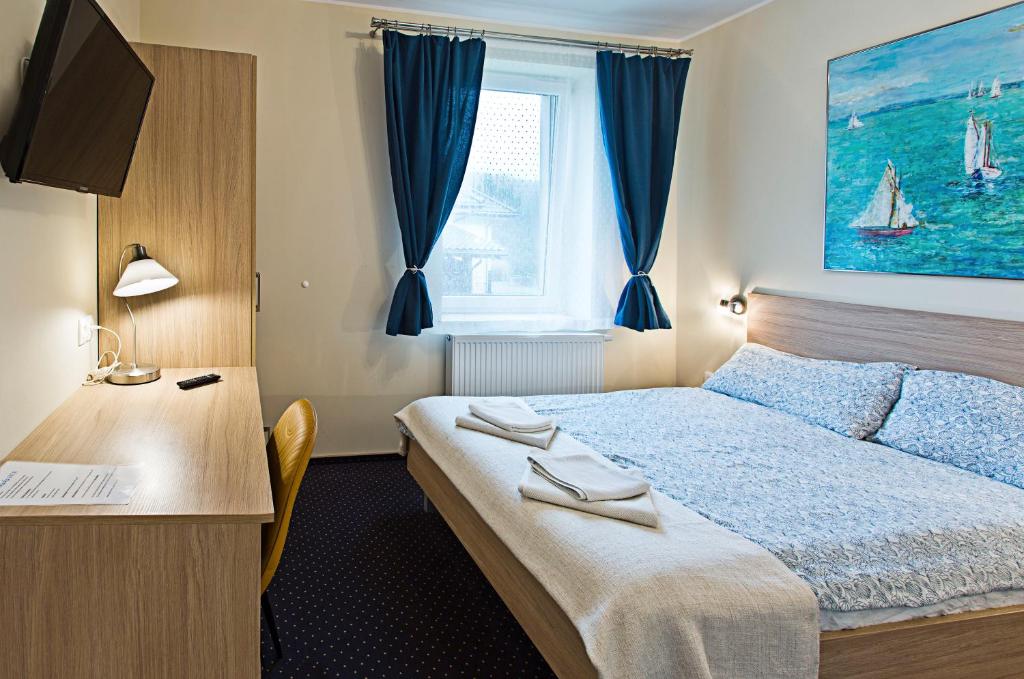 格丁尼亚Olkuska 107 A的配有一张床、一张书桌和一扇窗户的酒店客房
