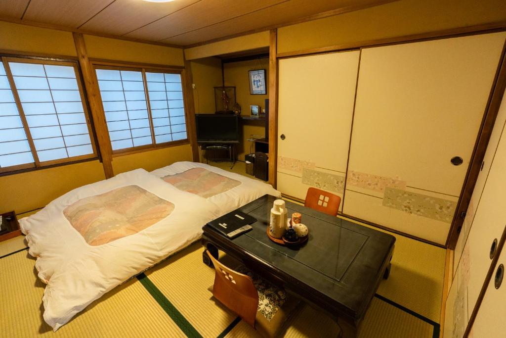 京都藤家旅馆的一间设有床铺和桌子的房间