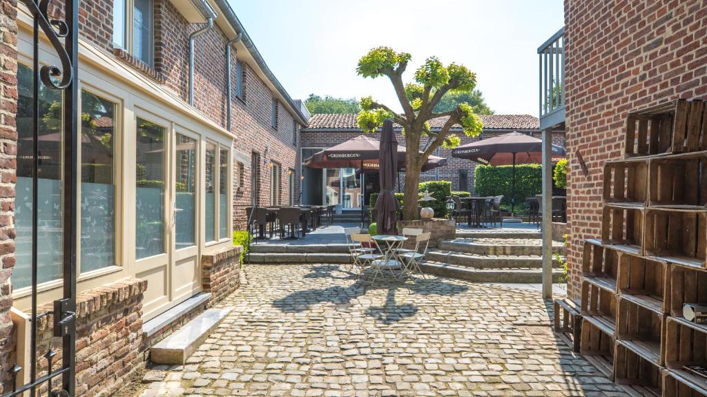通厄伦Hoeve de Sterappel的一座带砖砌建筑和树的庭院
