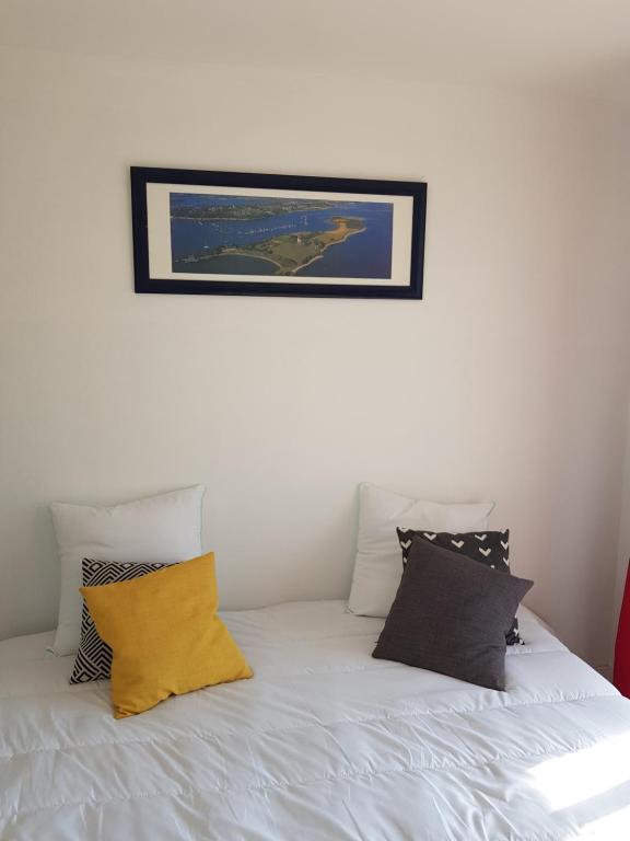 乌伊斯特勒昂studio front de mer的一张带枕头的白色床和墙上的照片