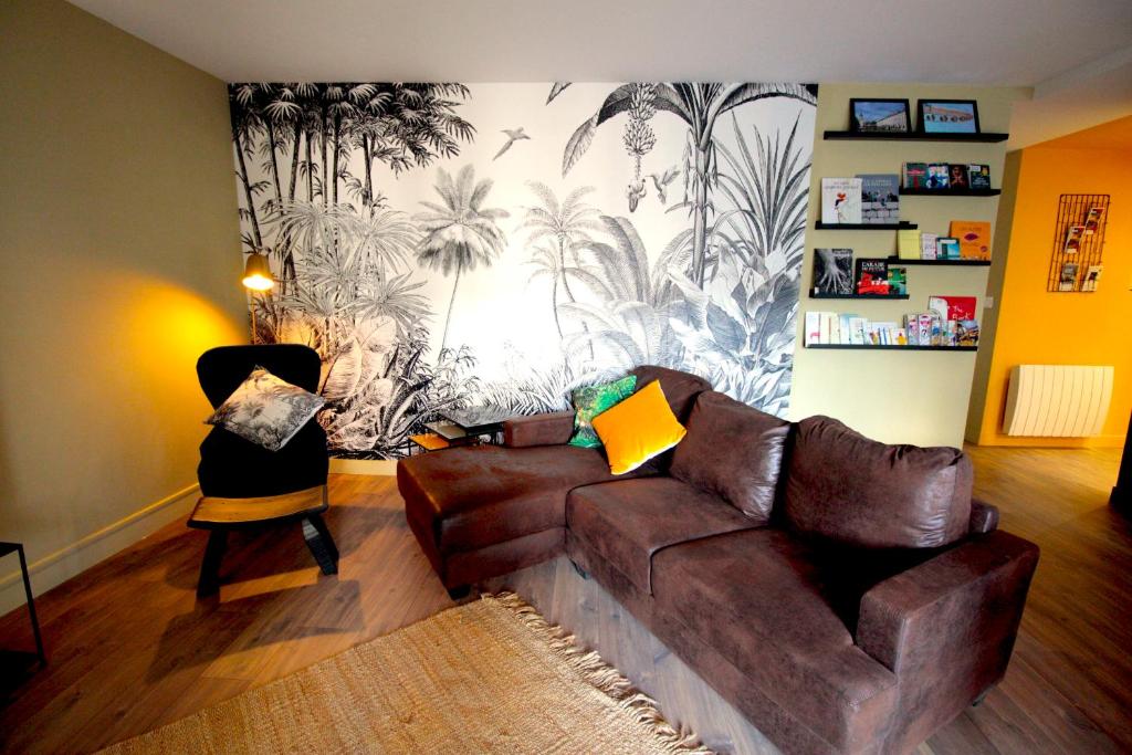 里昂Mon Appart A GERLAND II的客厅配有棕色沙发和壁画