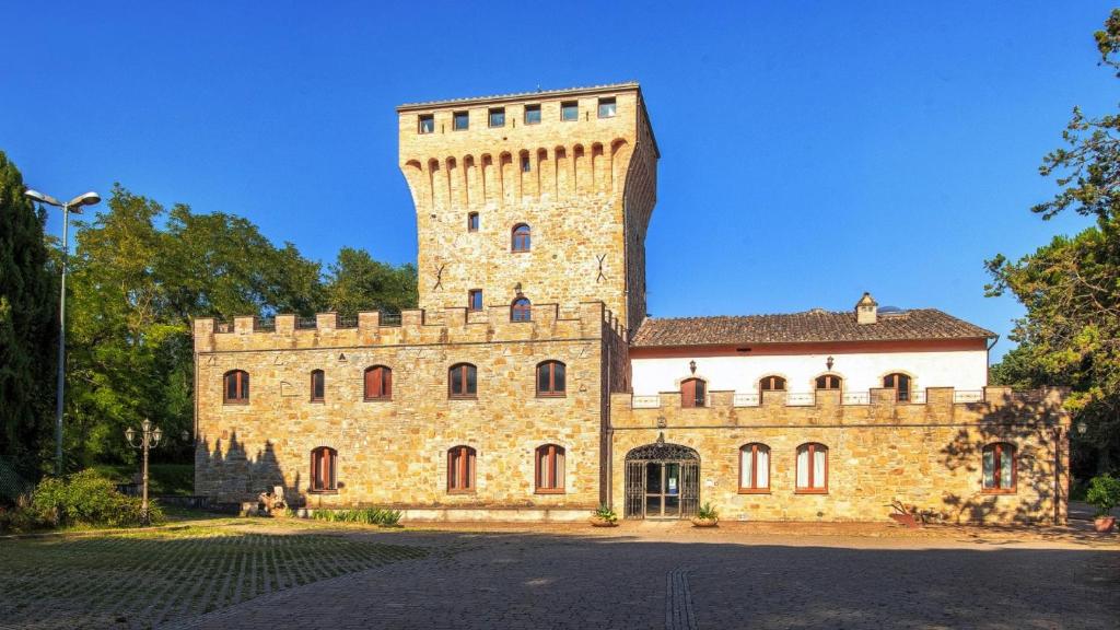 阿西西Torrenova di Assisi Country House的一座大型石头建筑,上面有一座塔